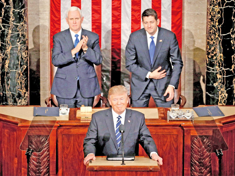 ترامب وخلفه نائبه مايك بنس ورئيس مجلس النواب بول ريان خلال كلمته في الكونغرس مساء أمس الأول (رويترز)