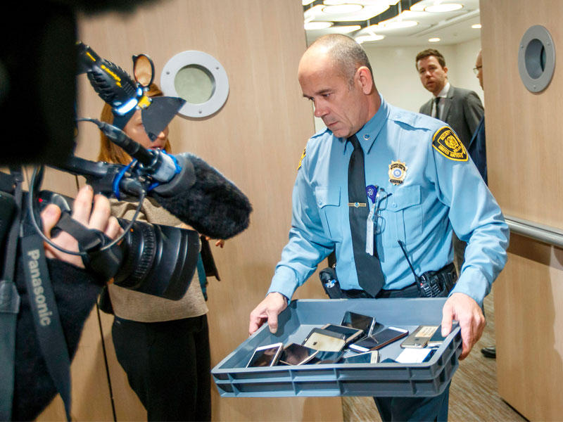 رجل أمن يجمع هواتف المشاركين في المحادثات داخل المقر الأوروبي للأمم المتحدة بجنيف أمس (أ ف ب)