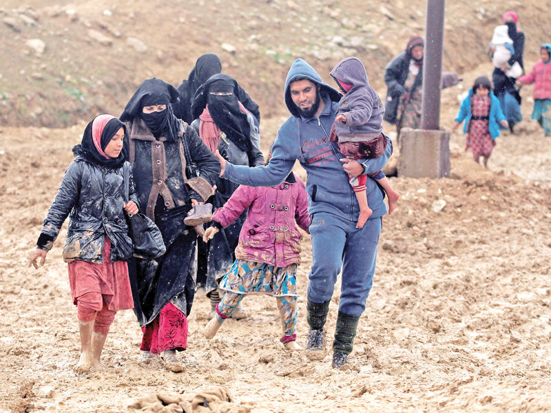 نازحون تحت المطر وسوء الأحوال الجوية هربوا من تنظيم «داعش» من الموصل أمس            (رويترز) 