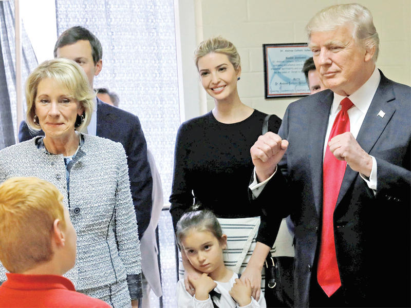 ترامب ووزيرة التعليم بيتسي ديفوس وجاريد كوشنر مستشاره وزوج ابنته ايفانكا في مدرسة سانت اندرو الكاثوليكية في فلوريدا أمس الأول     (رويترز)