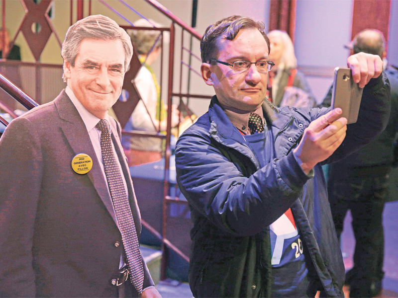 رجل يلتقط صورة بجانب مجسم لفيون في مدينة أوبارفيلييه أمس t(أ ف ب)