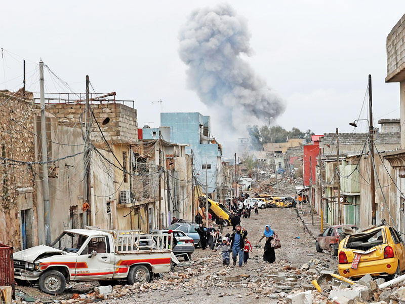 عراقيون يفرون من أحد أحياء غرب الموصل أمس (رويترز)