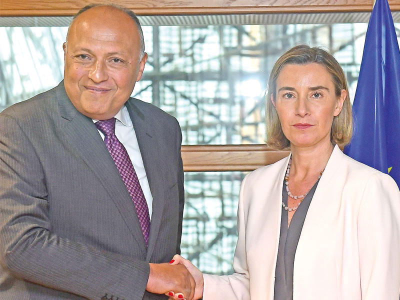 وزير الخارجية المصري سامح شكري مصافحاً مسؤولة السياسة الخارجية بالاتحاد الأوروبي فيدريكا موغيريني في بروكسل أمس tttt     (أ ف ب)