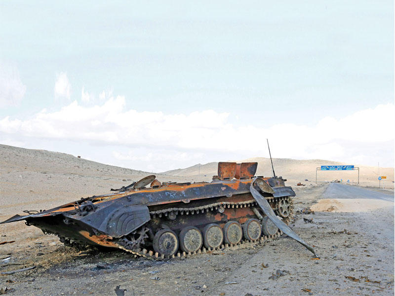 دبابة مدمرة على مدخل مدينة تدمر الأثرية أمس الأول (إي بي إيه)