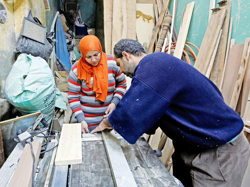 تظهر تقديرات حكومية أن المرأة المصرية تتولى منفردة إعالة نحو ثلاثين في المائة من الأسر وتسعى إلى تقديم يد العون لها من خلال تدريبها على بعض الحرف اليدوية التي تسهم في أن تحقق لها الاكتفاء الاقتصادي. وفي الصورة سيدة تعرف باسم «الأسطى أسماء» وتعمل داخل ورشة لصناعة الاثاث بالقاهرة (رويترز)