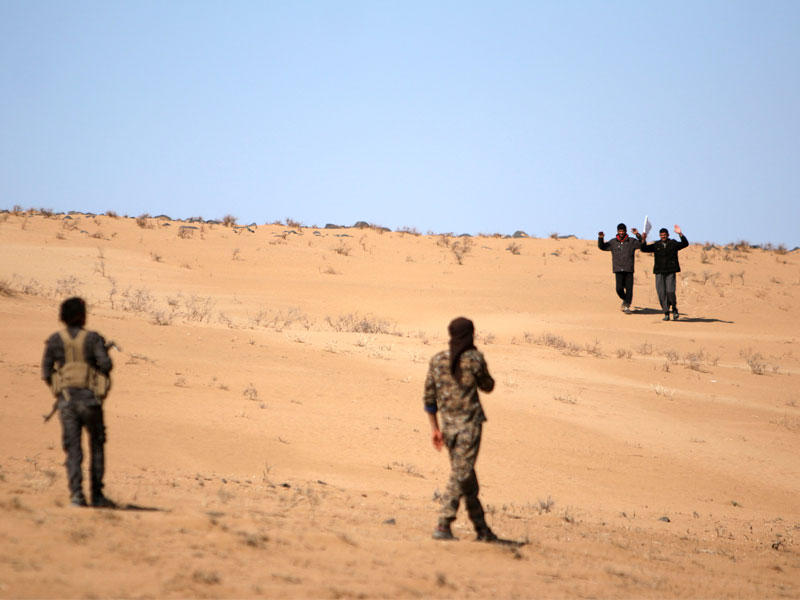 سوريان فرا من مناطق القتال في الرقة يتقدمان باتجاه مقاتلين في «قسد» أمس الأول (رويترز)