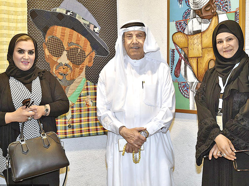 سامي محمد متوسطاً فنانتين مشاركتين في معرض «ومضات ملونة»