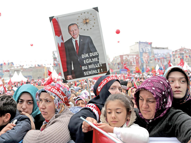 أنصار الرئيس التركي يرفعون صوره خلال تجمع مؤيد لتوسيع صلاحياته حضره إردوغان في إسطنبول أمس (إي بي أيه)