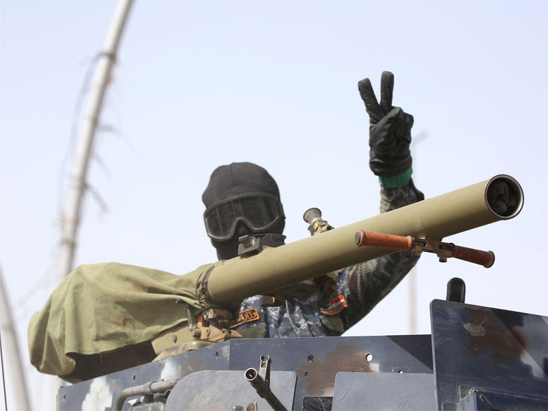 عضو الشرطة الفيدرالية يرفع علامة النصر خلال معركة مع داعش