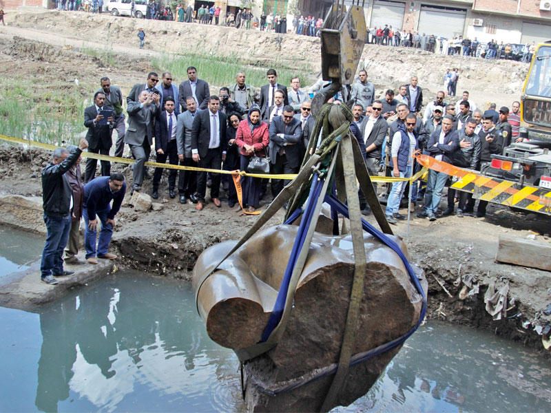 بعض الأهالي يتابعون رفع الجزء العلوي من تمثال رمسيس بحي المطرية شمال شرق القاهرة أمس تمهيدا لنقله إلى المتحف الكبير بالجيزة (الجريدة)
