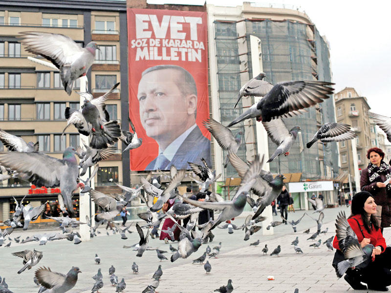 صورة لإردوغان في ساحة تقسيم بإسطنبول أمس كتب عليها عبارة تدعو إلى تأييد الإصلاحات الدستورية (رويترز)