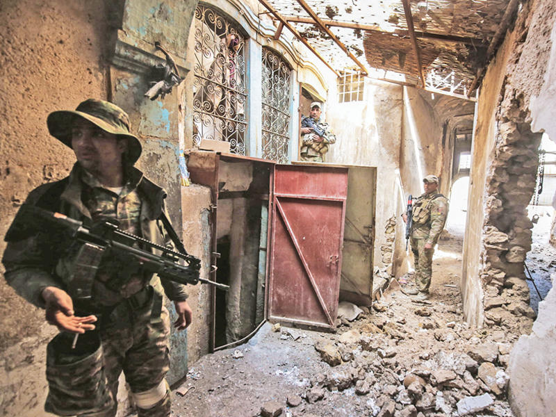 جنود عراقيون من فرقة «الرد السريع» داخل أحد أحياء وسط الموصل أمس الأول    (أ ف ب)