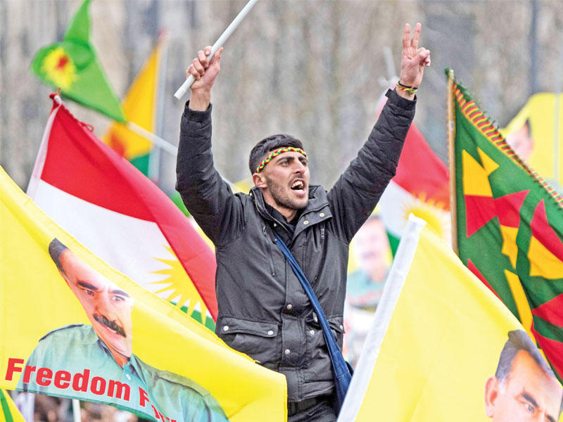 متظاهرون يرفعون صور زعيم حزب «العمال الكردستاني» المحظور عبدالله أوغلان خلال مسيرة حاشدة في فرانكفورت غرب ألمانيا أمس الأول (أ ف ب)