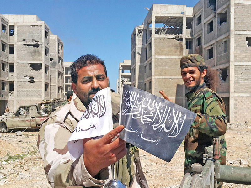 عنصران من قوات حفتر يرفعان علمين للفصائل الإسلامية التي طُردت أمس الأول من بنغازي   (رويترز)