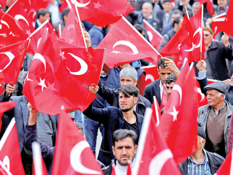 أتراك يحملون علم بلادهم خلال تجمع انتخابي في دياربكر اليوم (رويترز)