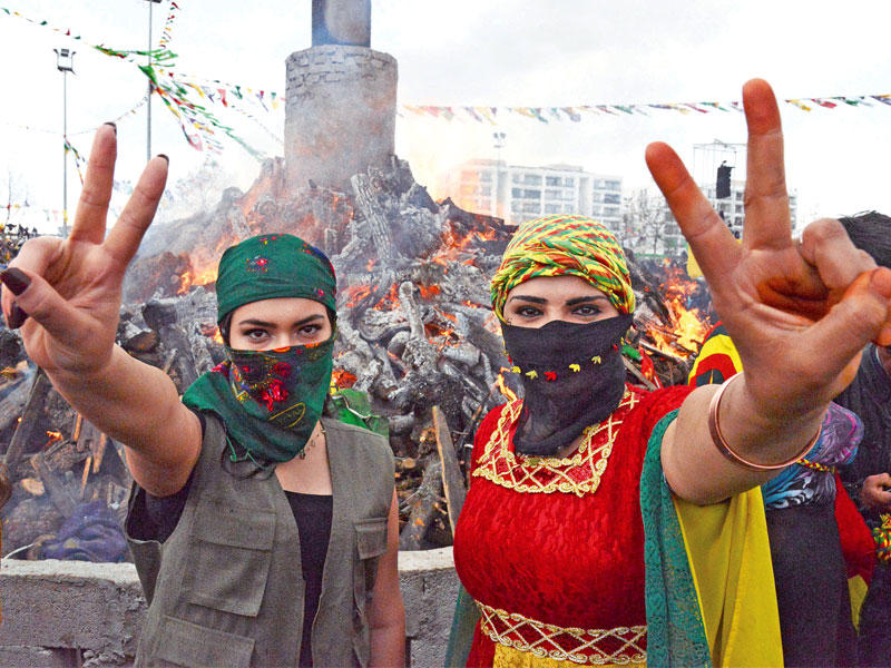 كرديتان تحتفلان خلال تجمع حاشد بمناسبة «عيد النوروز» الذي يصادف اليوم الأول من فصل الربيع في منطقة ديار بكر ذات الغالبية الكردية جنوب شرق تركيا أمس (أ ف ب)