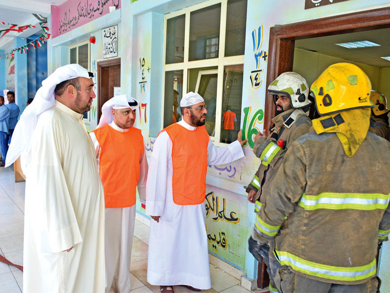 رجال الإطفاء خلال عملية الإخلاء أمس (تصوير جمال عبدالله)n