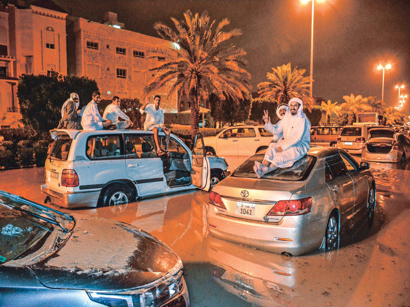 سيارات عالقة وأصحابها فوقها هرباً من بحيرات الأمطار أمس الأول