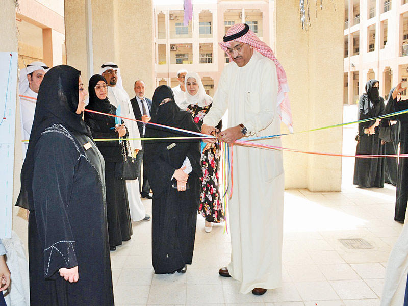 العنزي مفتتحاً معرض مشاريع الطالبات وتبدو مديرة مدرسة النهضة الثانوية حنان اللهو