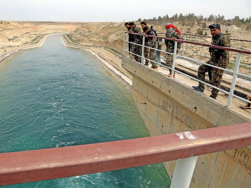 مجموعة من «قسد» تتفقد سد الطبقة على نهر الفرات بعد استعادته أمس (أ ف ب)