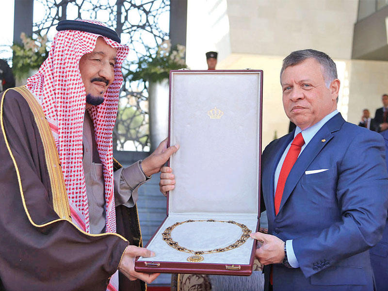 العاهل الأردني مقلداً الملك سلمان أرفع وسام أردني أمس (بترا) 