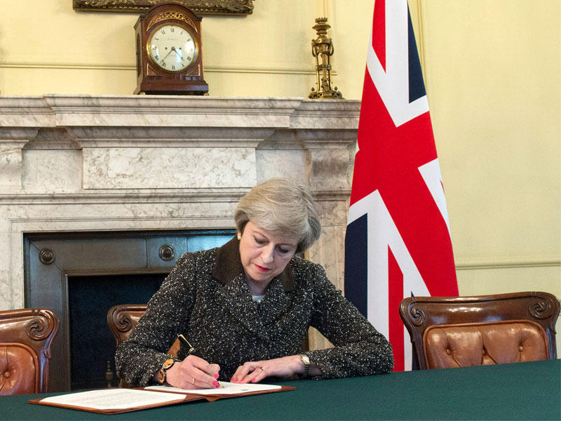 رئيسة الوزراء البريطانية تيريزا ماي توقع رسالة إخطار إلى رئيس المجلس الأوروبي تبين فيها الانسحاب من الاتحاد الأوروبي