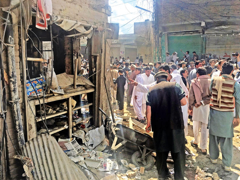 باكستانيون في محيط موقع الانفجار الذي استهدف المسجد شمال غرب باكستان أمس (رويترز)