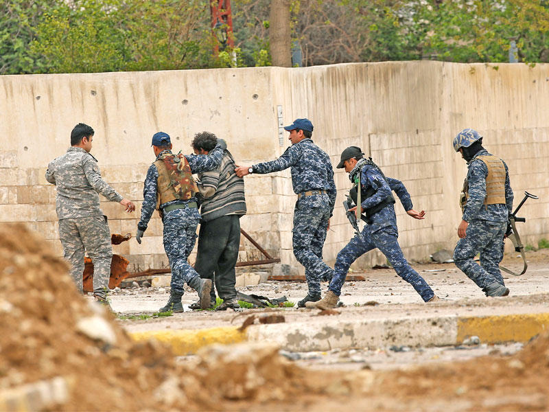 جنود يعتقلون «داعشياً» في الموصل القديمة أمس (رويترز)