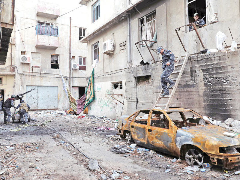 عناصر من الشرطة الاتحادية خلال تمشيط أحد شوارع الموصل أمس (أ ف ب)