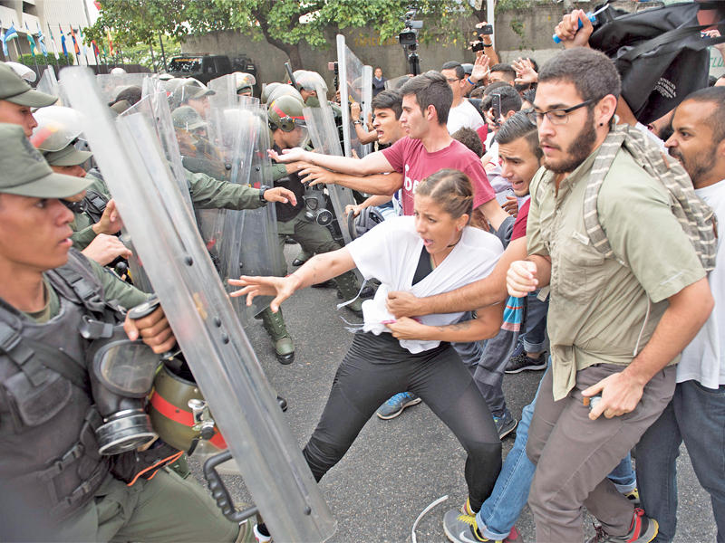 ناشطون معارضون يواجهون قوات الأمن أمام مقر المحكمة الدستورية في كراكاس أمس الأول (أ ف ب)n