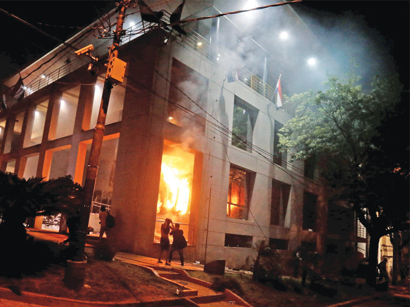 متظاهرون أمام مقر الكونغرس المحترق مساء أمس الأول (أ ف ب)