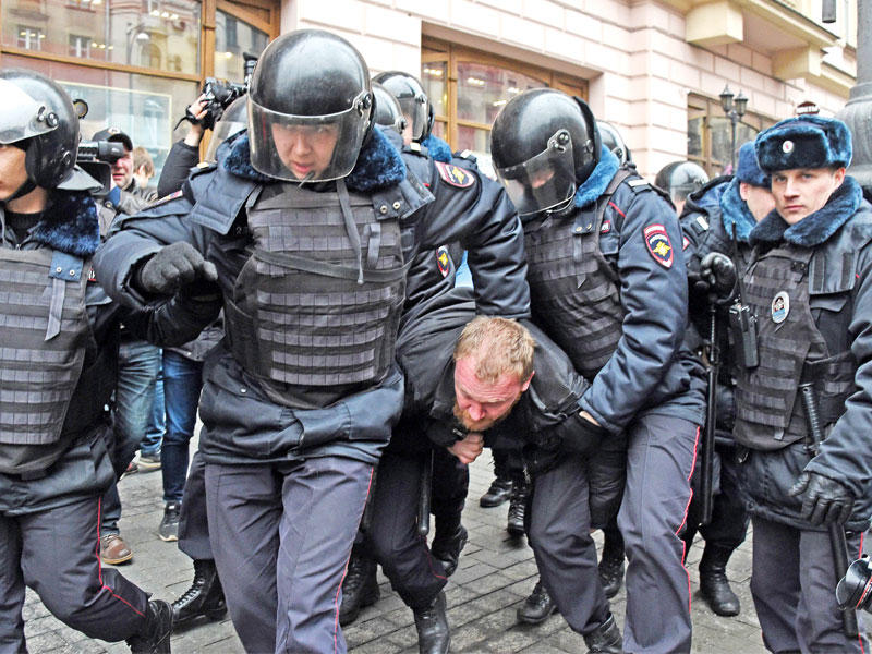 شرطيون روس يتعاملون بخشونة مع متظاهر في موسكو اليوم (أ ف ب)
