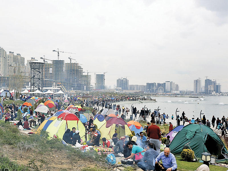 إيرانيون على ضفة بحيرة طهران في آخر أيام الاحتفال بعيد نوروز  (إرنا)