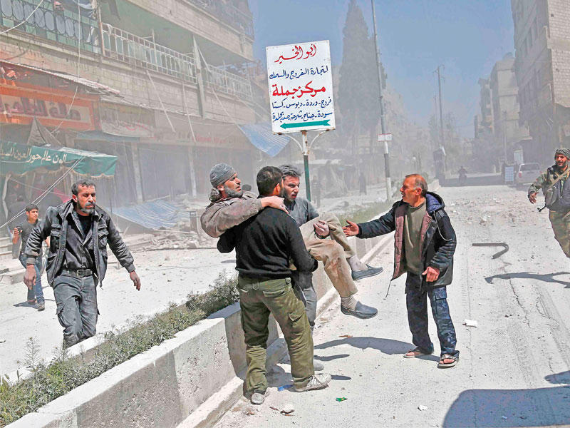 إجلاء سوري أصيب في غارة نظامية على حموريا بالغوطة الشرقية (أ ف ب)