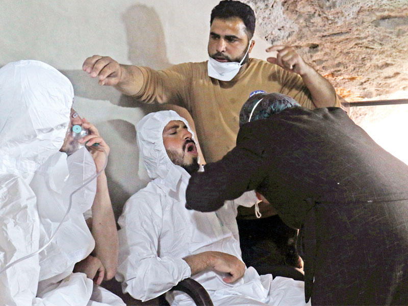 محاولات إسعاف بعض المصابين في هجوم خان شيخون أمس (رويترز)