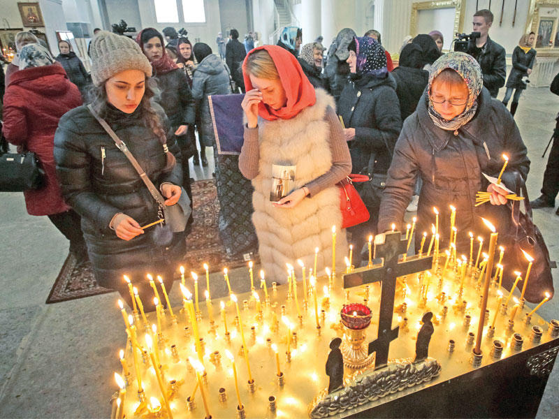 روس بينهم اقرباء لضحايا هجوم المترو يشاركون في مراسم دينية بكاتدرائية الثالوث الأقدس في بطرسبورغ أمس (رويترز)