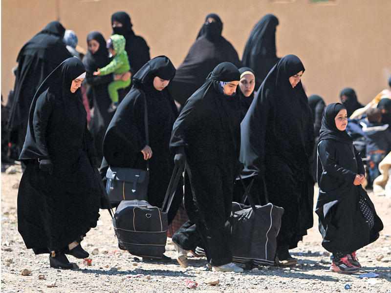 سوريات فررن من مدينة الرقة يحملن ممتلكاتهن في قرية المحمودلي غربها أمس الأول  (رويترز)