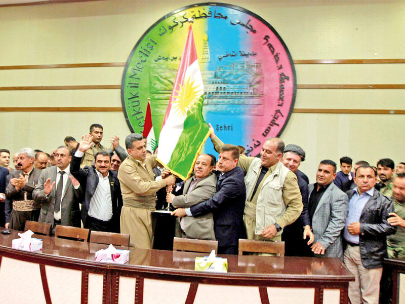 أكراد يرفعون علمهم داخل مجلس محافظة كركوك أمس (رويترز)