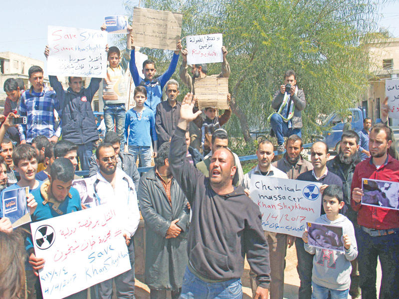 أهالي خان شيخون يتظاهرون ضد الأسد في موقع الهجوم الكيماوي أمس (أ ف ب)