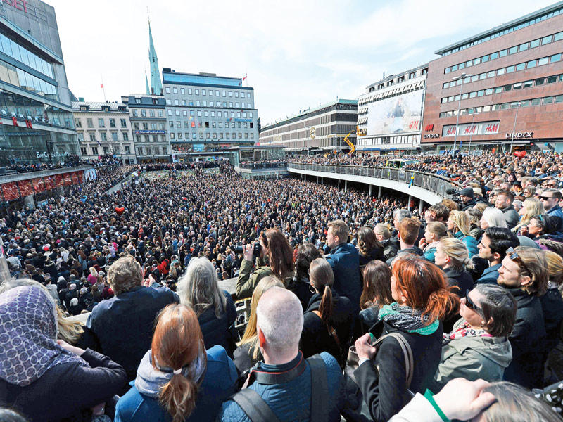 آلاف السويديين يشاركون أمس بوقفة تضامنية في استوكهولم مع ضحايا حادثة الدهس الإرهابية t(أ ف ب)
