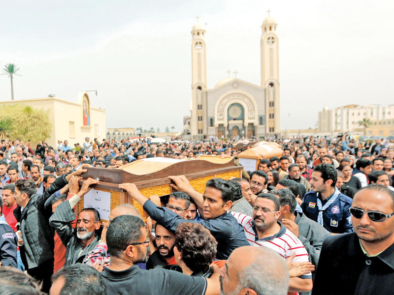 آلاف المصريين يشاركون في تشييع ضحايا مجزرة أحد السعف أمام كنيسة دير مار مينا في الإسكندرية أمس  (رويترز)