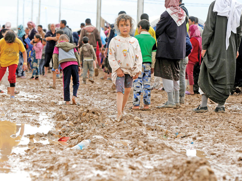 عراقيون نازحون من الموصل بعضهم حفاة رغم  الجو الماطر في مخيم حمام العليل اليوم (رويترز)