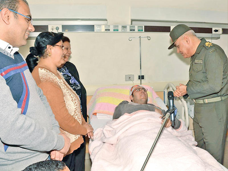 وزير الدفاع الفريق أول صدقي صبحي خلال زيارته لأحد مصابي تفجيري الكنيستين أمس الأول