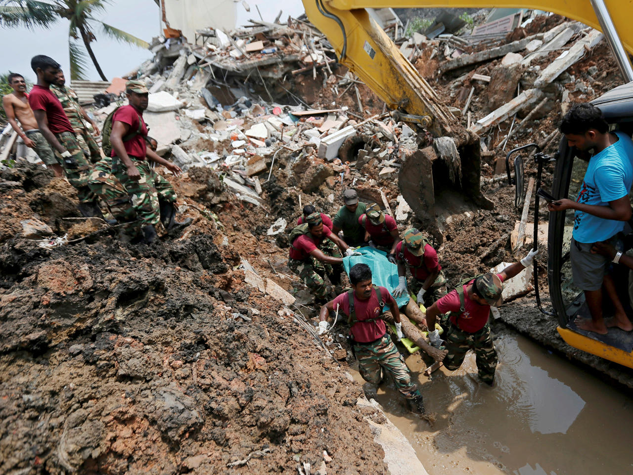 عناصر من الجيش يحملون ضحية ميتة خلال مهمة الإنقاذ بعد انهيار تفريغ القمامة ودفن العشرات من المنازل في كولومبو، سريلانكا
