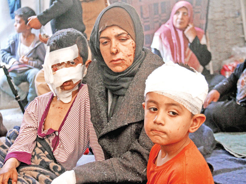 مصابة وولداها في تفجير الراشدين تنتظر بمخيم مؤقت في محافظة إدلب أمس الأول (أ ف ب)