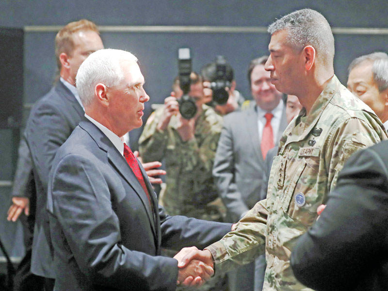 بنس يصافح قائد القوات الأميركية في كوريا الجنرال فينسنت بروكس أمس في سيول قبل مغادرته إلى طوكيو   (أ ف ب)