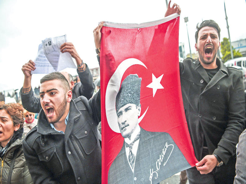 أتراك يحملون صورة أتاتورك يحتجون على نتائج التعديلات الدستورية في أنقرة أمس   (أ ف ب)