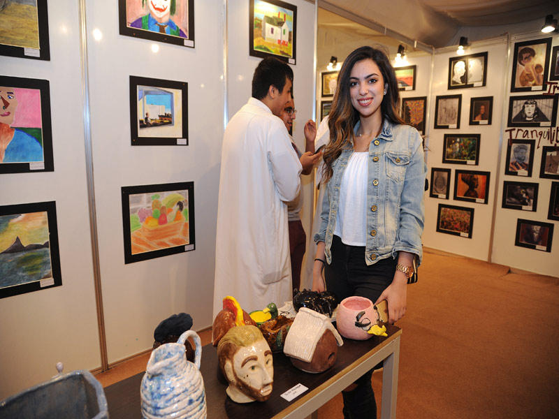 الطالبة دينا أبو لغد أمام أعمالها الفنية