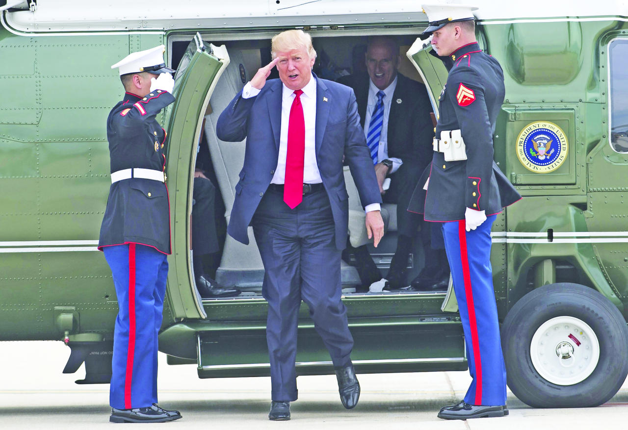 ترامب أثناء مغادرته المروحية الرئاسية في ويسكنسون أمس ( أ ف ب)