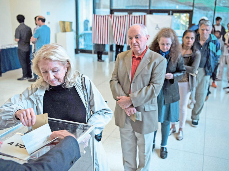 فرنسية تدلي بصوتها في الجولة الأولى من الانتخابات الرئاسية داخل مقر السفارة الفرنسية بواشنطن أمس (أ ف ب)